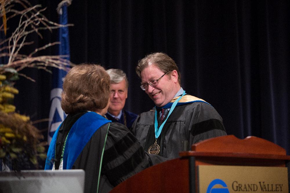 Gayle Davis Shakes hands with faculty member as President Emeritus Haas looks on
